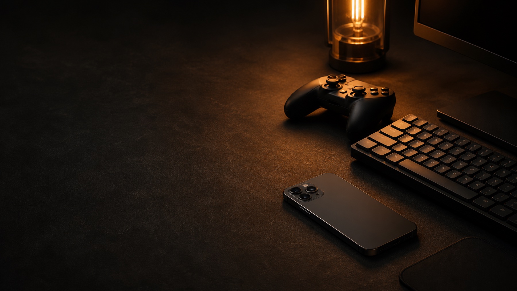 Dark gaming desk with an iPhone, controller and keyboard